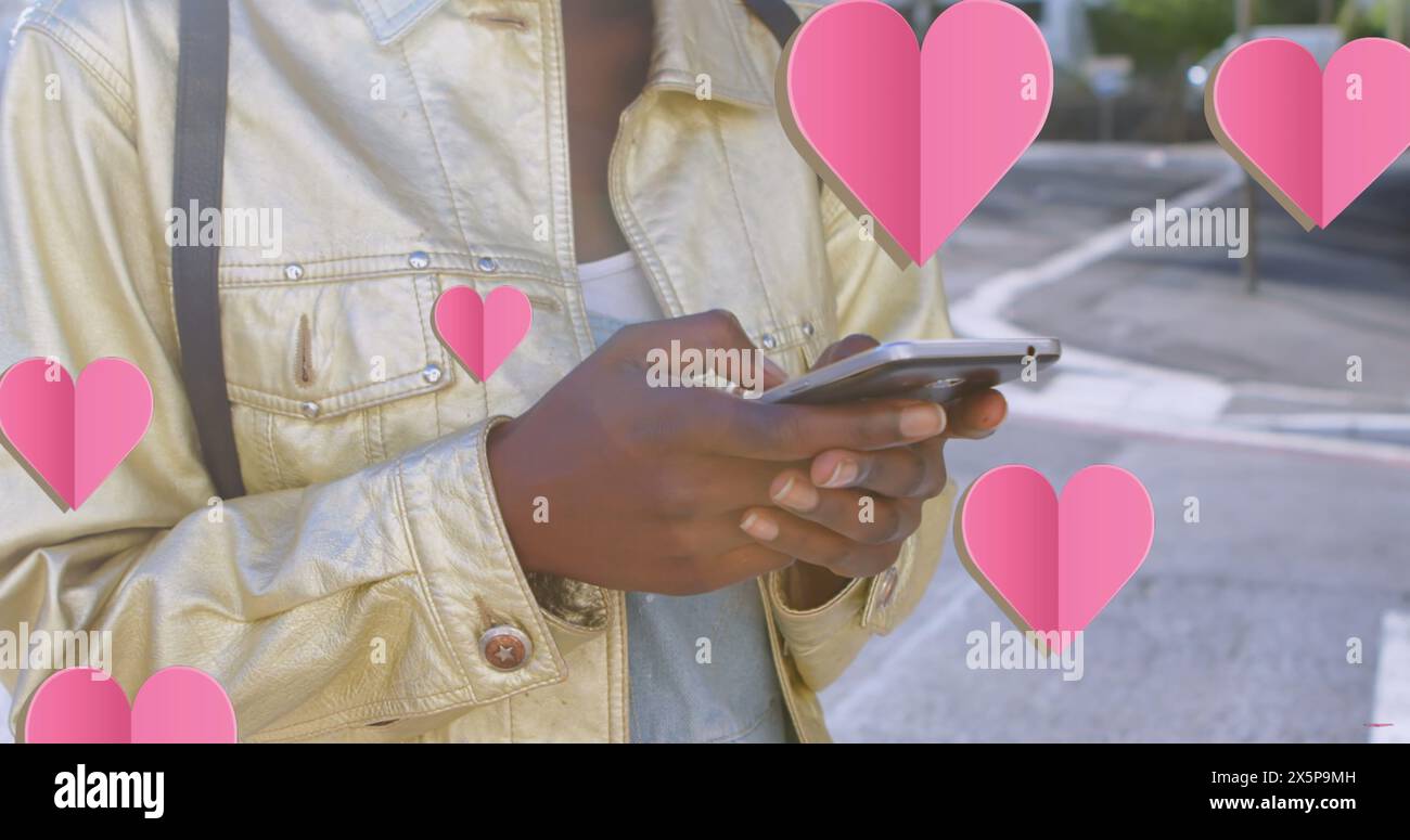 Une jeune femme afro-américaine portant une veste jaune texturant sur son smartphone Banque D'Images