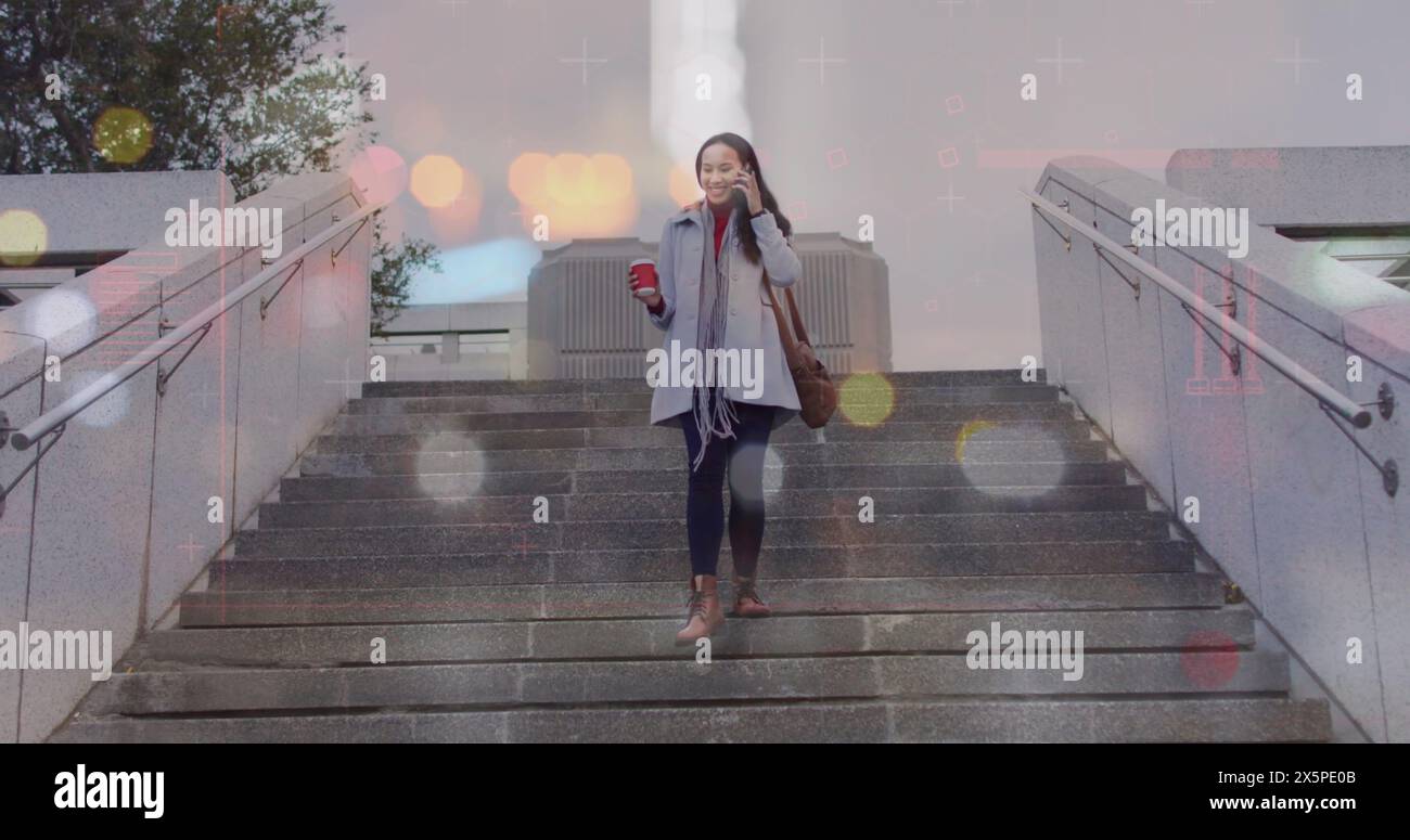 Image de reflets d'objectif au-dessus d'une femme asiatique prenant sur smartphone tout en descendant sur les marches de la ville Banque D'Images