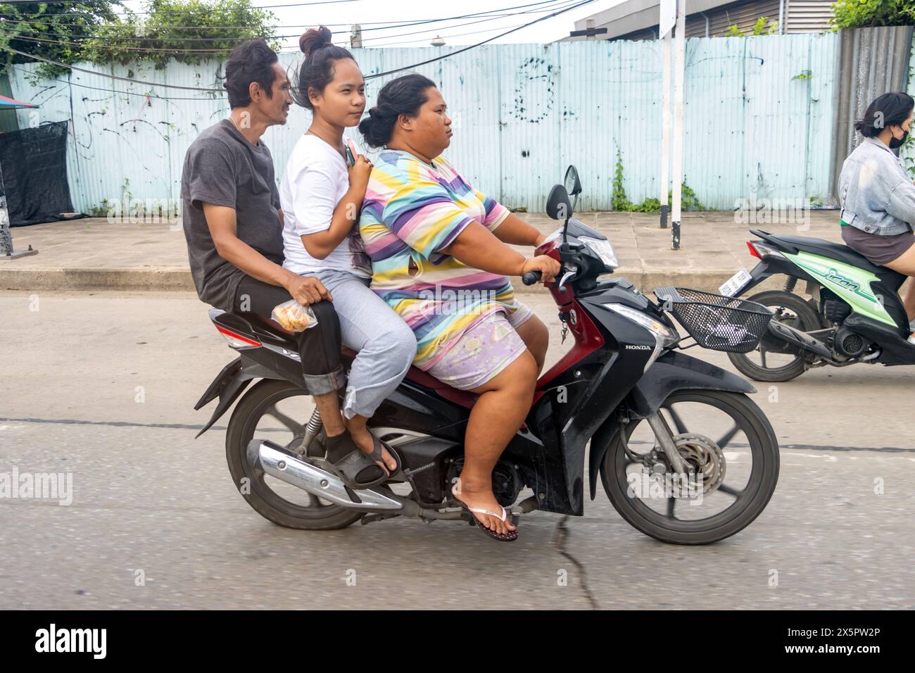 SAMUT PRAKAN, THAÏLANDE, OCT 07 2023, le trio roule en moto dans la rue. Banque D'Images