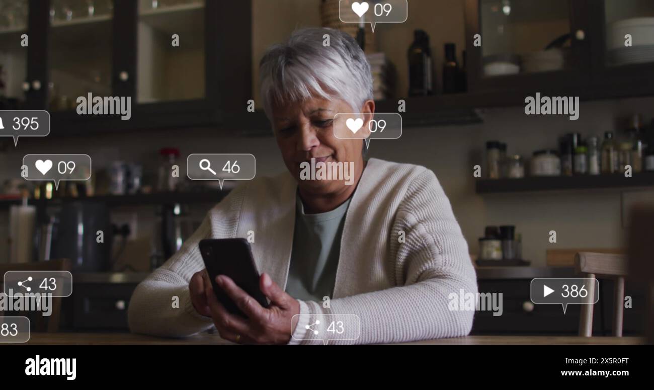 Femme biraciale senior avec les cheveux gris regardant le smartphone Banque D'Images