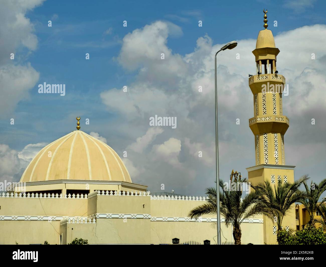 Le Caire, Egypte, 24 mars 2024 : haut minaret et dôme d'une mosquée contre un beau ciel bleu avec des nuages à la lumière du jour, les mosquées sont le lieu des worshis Banque D'Images