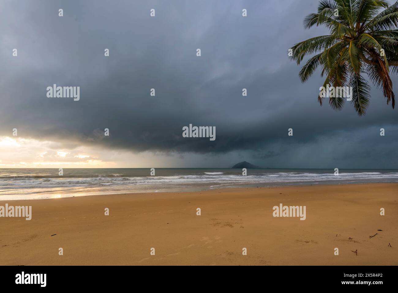 Une tempête de pluie tropicale et de lourds nuages gris bas approchant Mission Beach par le sud-est dans l'extrême nord du Queensland, en Australie Banque D'Images