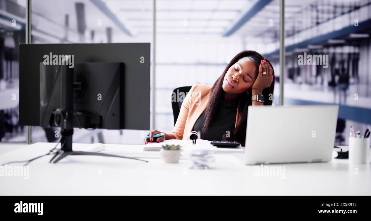 Jeune femme d'affaires fatiguée de calculer l'impôt à la réception au bureau Banque D'Images