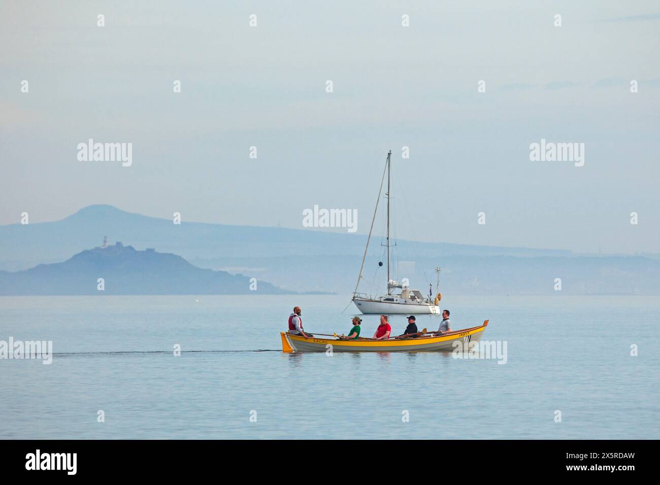 Portobello, Édimbourg, Écosse, Royaume-Uni. 11 mai 2024. Matin brumeux à 14 degrés centigrades pour ceux qui sortent pour exrcise sur la plage et le Firth of Forth. Sur la photo : planches de paddle et yacht de plaisance amarré sur Firth of Forth avec une île brumeuse d'Inchkeith et Lomond Hills en arrière-plan. Credit : Arch White/Alamy Live news. Banque D'Images