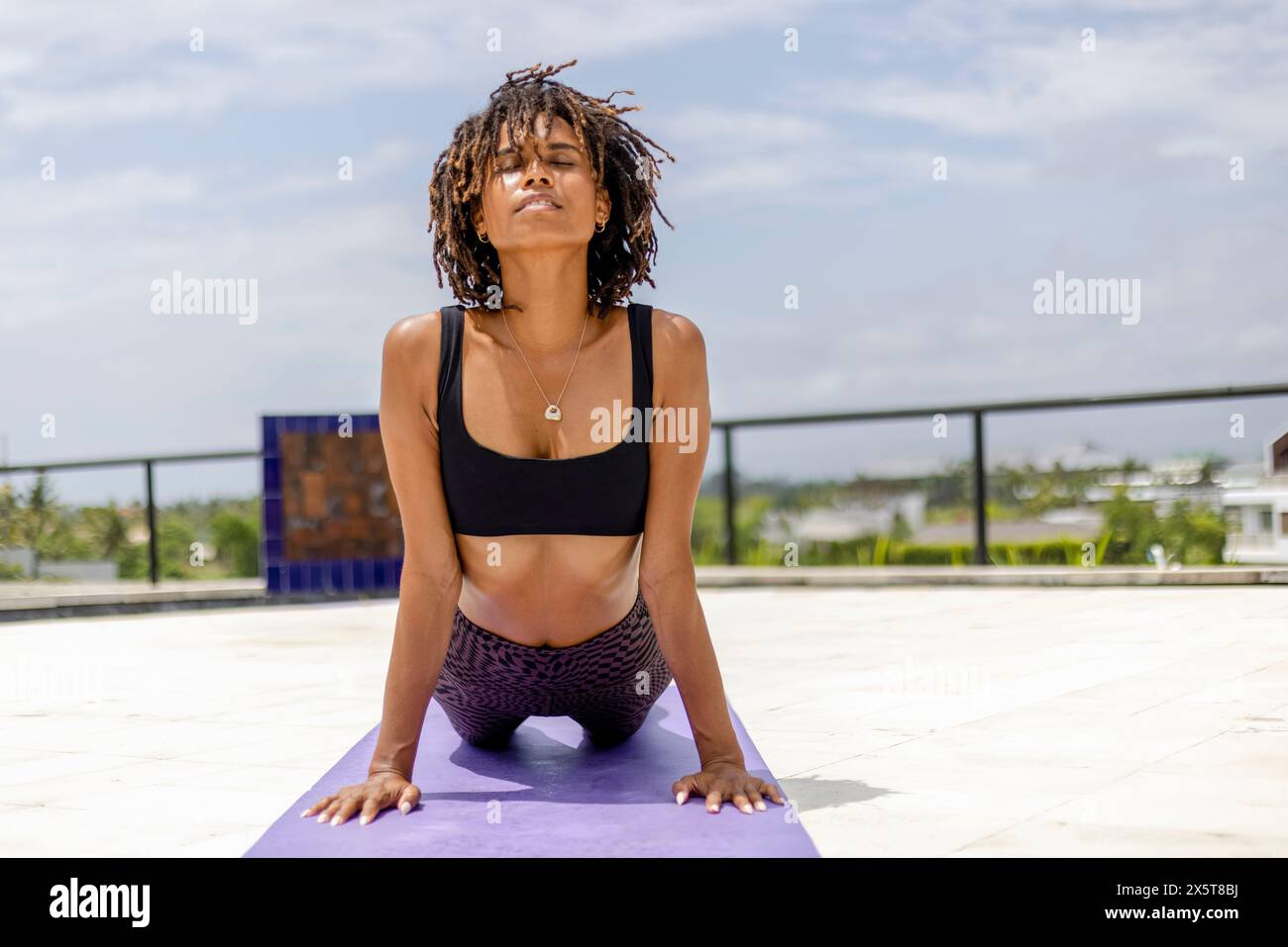 Femme dans Urdhvamukhasvanasana (posture du chien orientée vers le haut) sur la terrasse Banque D'Images