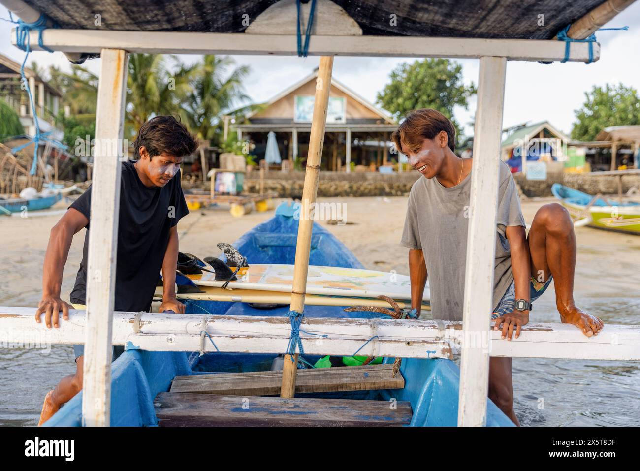 Indonésie, Lombok, Surfers entrant en bateau sur la mer Banque D'Images