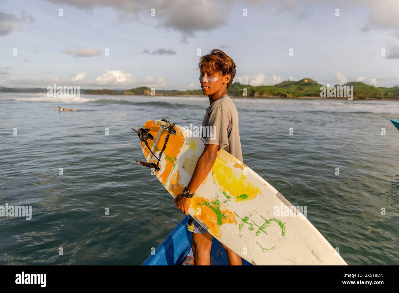Indonésie, Lombok, surfer debout avec planche de surf sur le bateau et regardant la vue sur la mer Banque D'Images