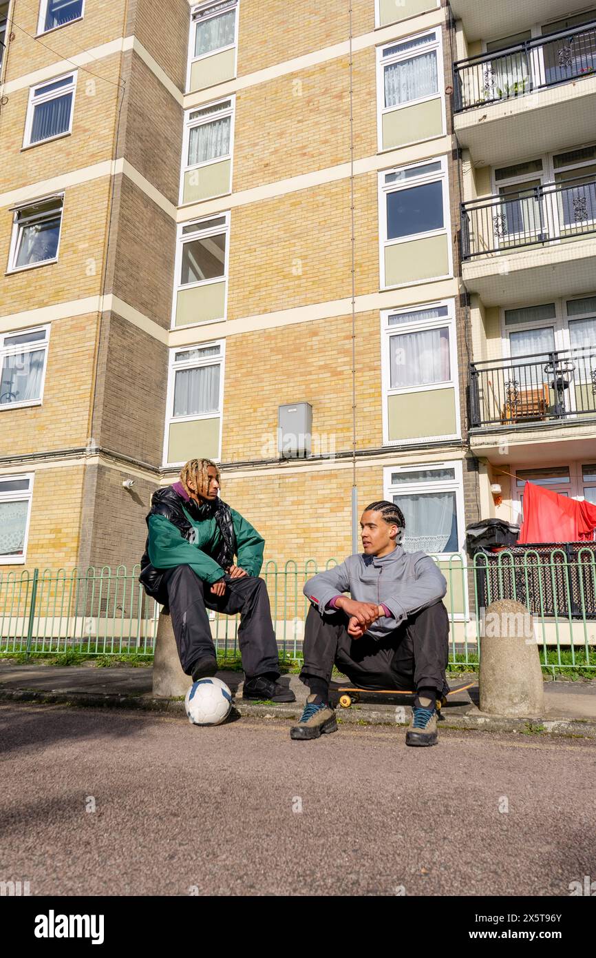 Jeunes amis masculins traînant dans un quartier résidentiel Banque D'Images