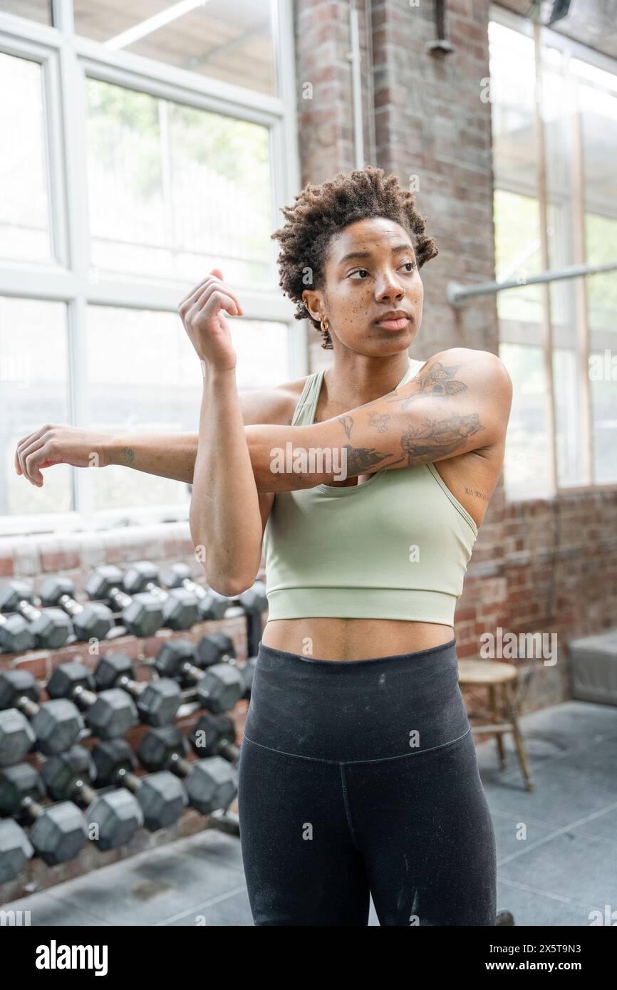 Femme étirant les bras au gymnase avant l'entraînement Banque D'Images