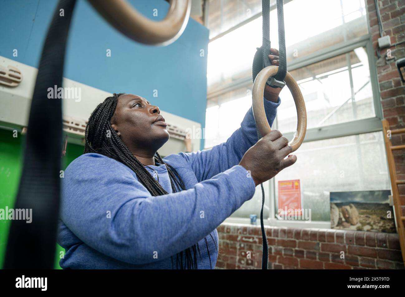 Femme préparant des anneaux de gymnastique pour l'entraînement dans le gymnase Banque D'Images