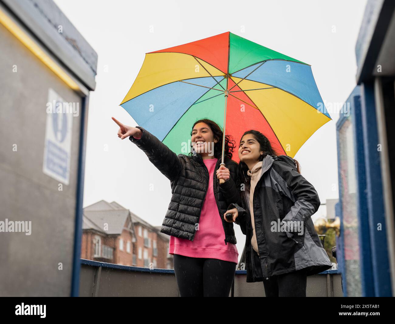 Jeunes femmes pointant et regardant la vue depuis le bateau le jour de pluie Banque D'Images