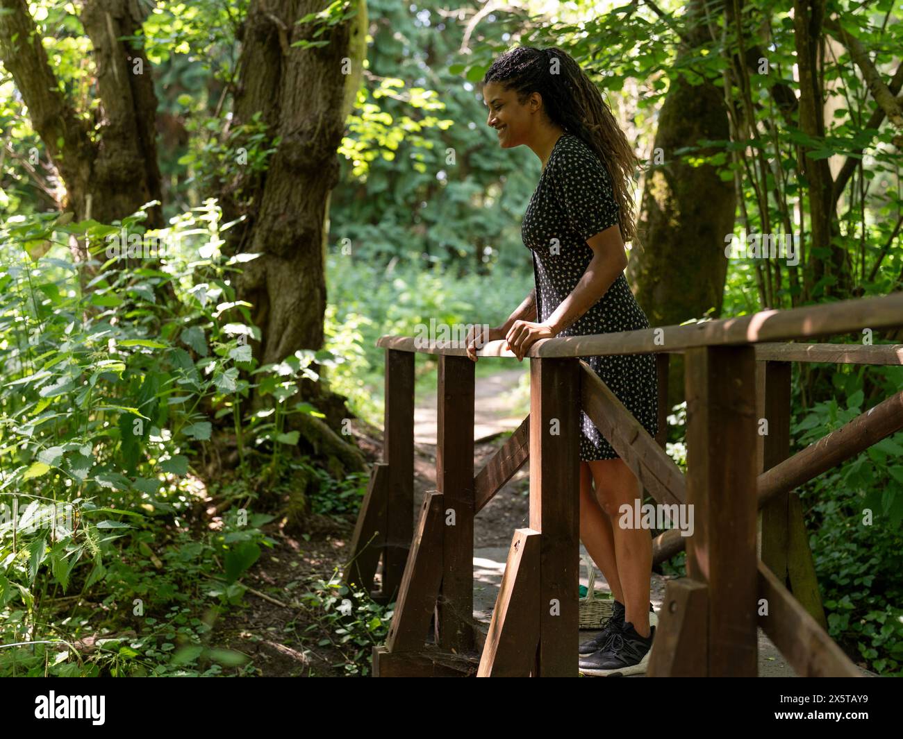 Femme debout sur la passerelle dans la forêt Banque D'Images