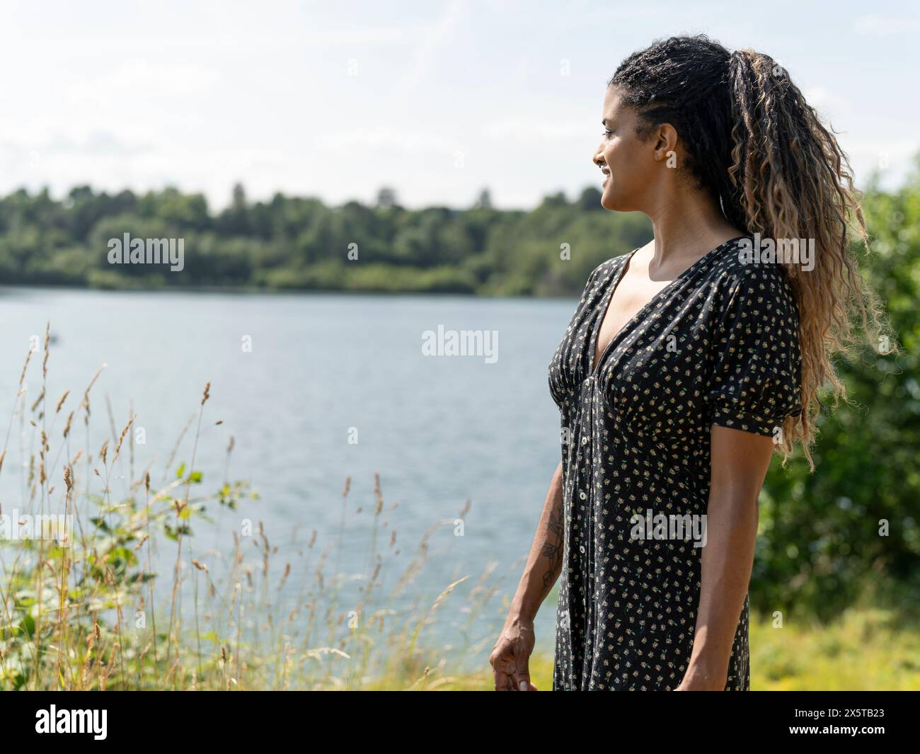 Portrait de femme regardant le lac par jour ensoleillé Banque D'Images
