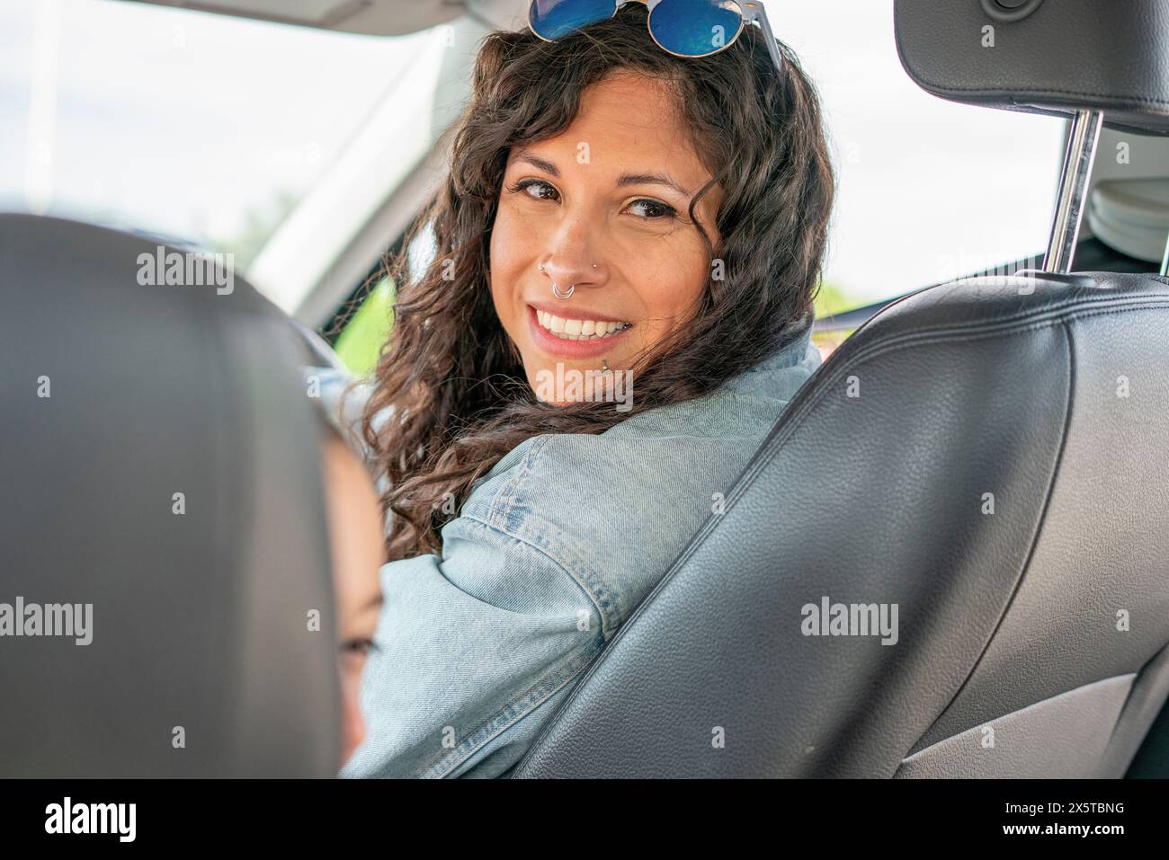 Portrait d'une femme souriante assise en voiture Banque D'Images