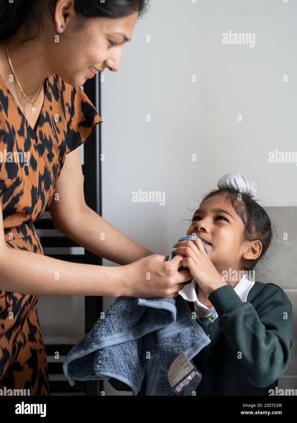 Mère aidant son fils (6-7) à sécher le visage avec une serviette Banque D'Images