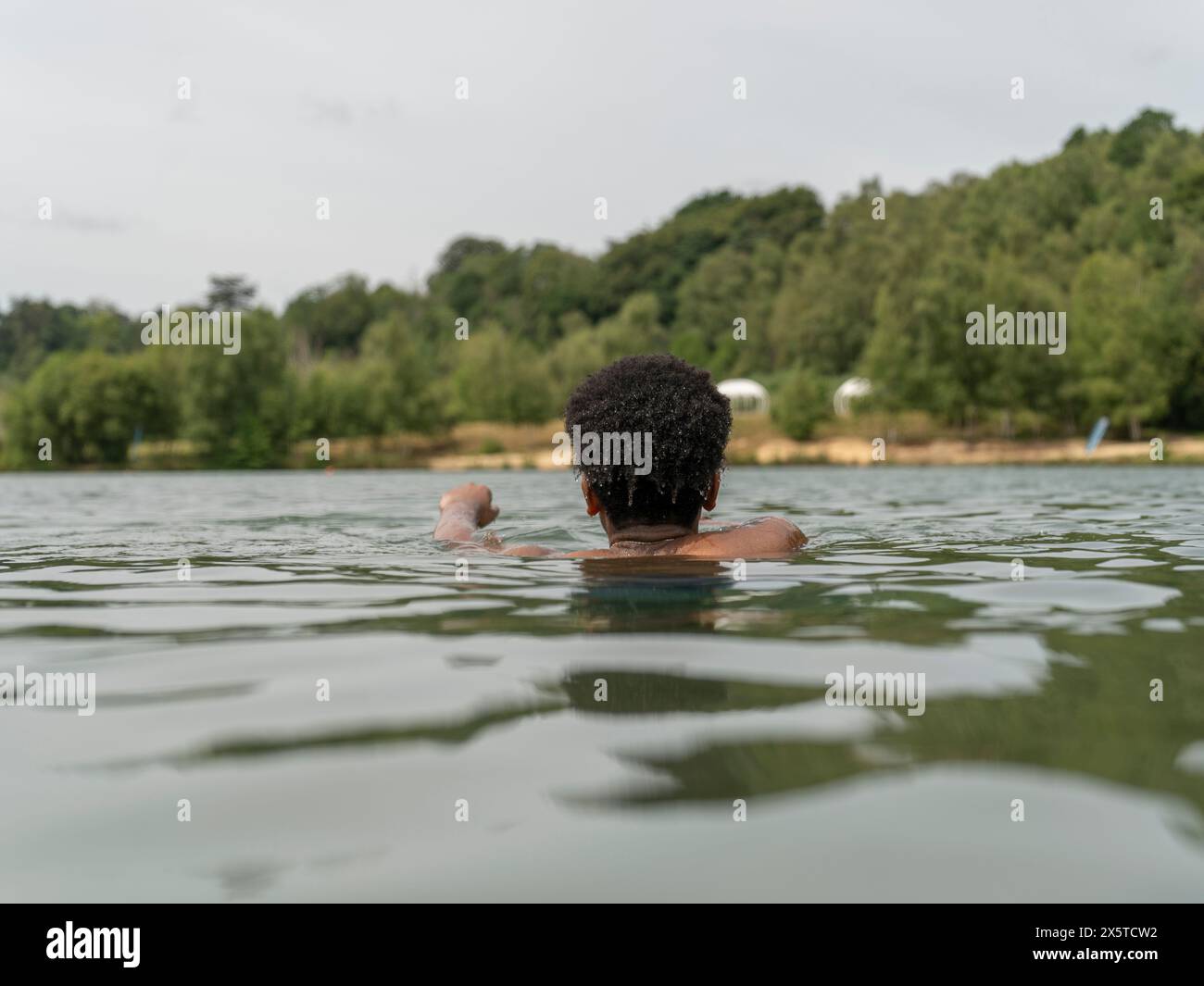 Jeune homme nageant dans le lac Banque D'Images