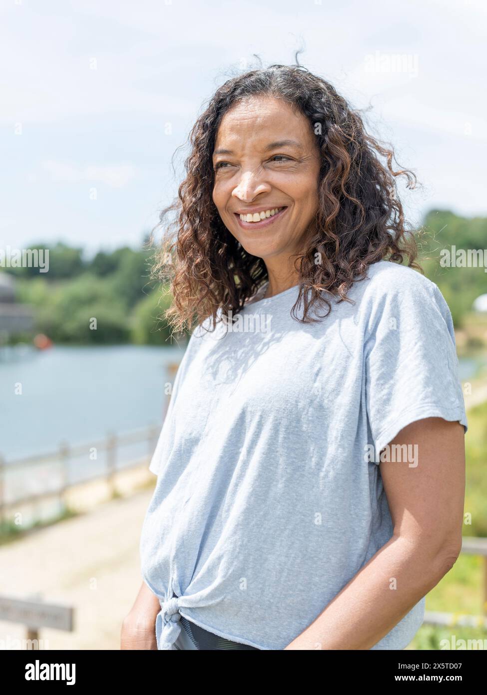 Portrait d'une femme souriante regardant le lac Banque D'Images