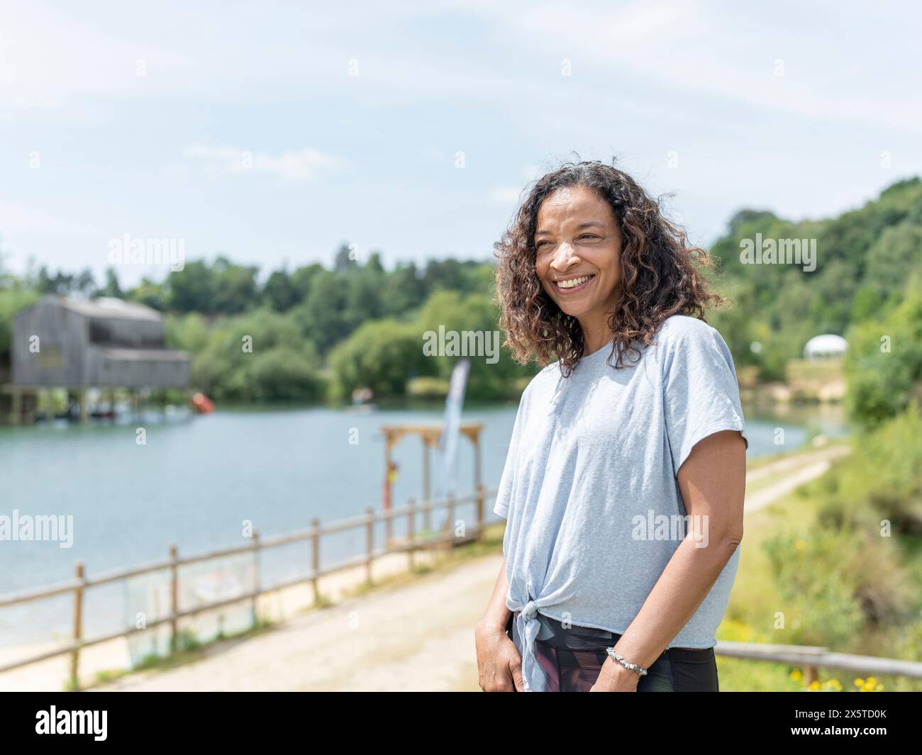 Portrait d'une femme souriante regardant le lac Banque D'Images