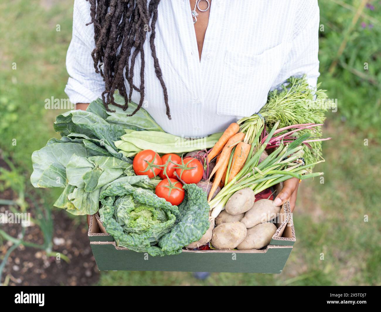 Femme mature tenant des légumes du jardin Banque D'Images