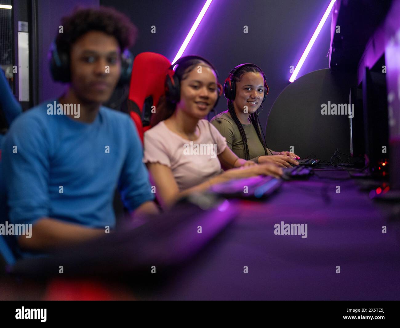 Portrait d'amis jouant à des jeux vidéo dans le club de jeu Banque D'Images