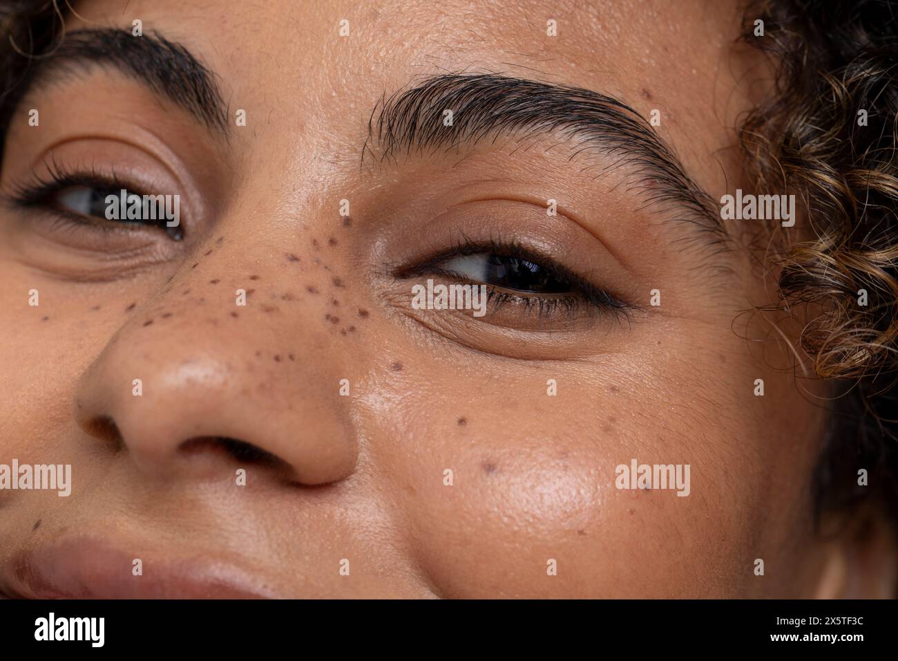 Gros plan d'une femme avec des yeux bruns et des taches de rousseur Banque D'Images
