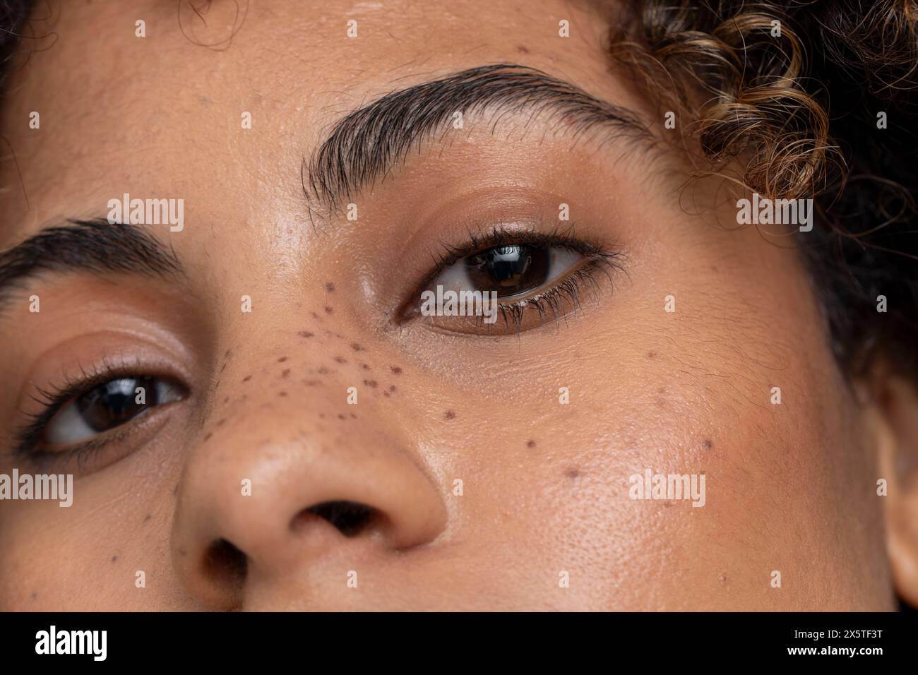 Gros plan d'une femme avec des yeux bruns et des taches de rousseur Banque D'Images