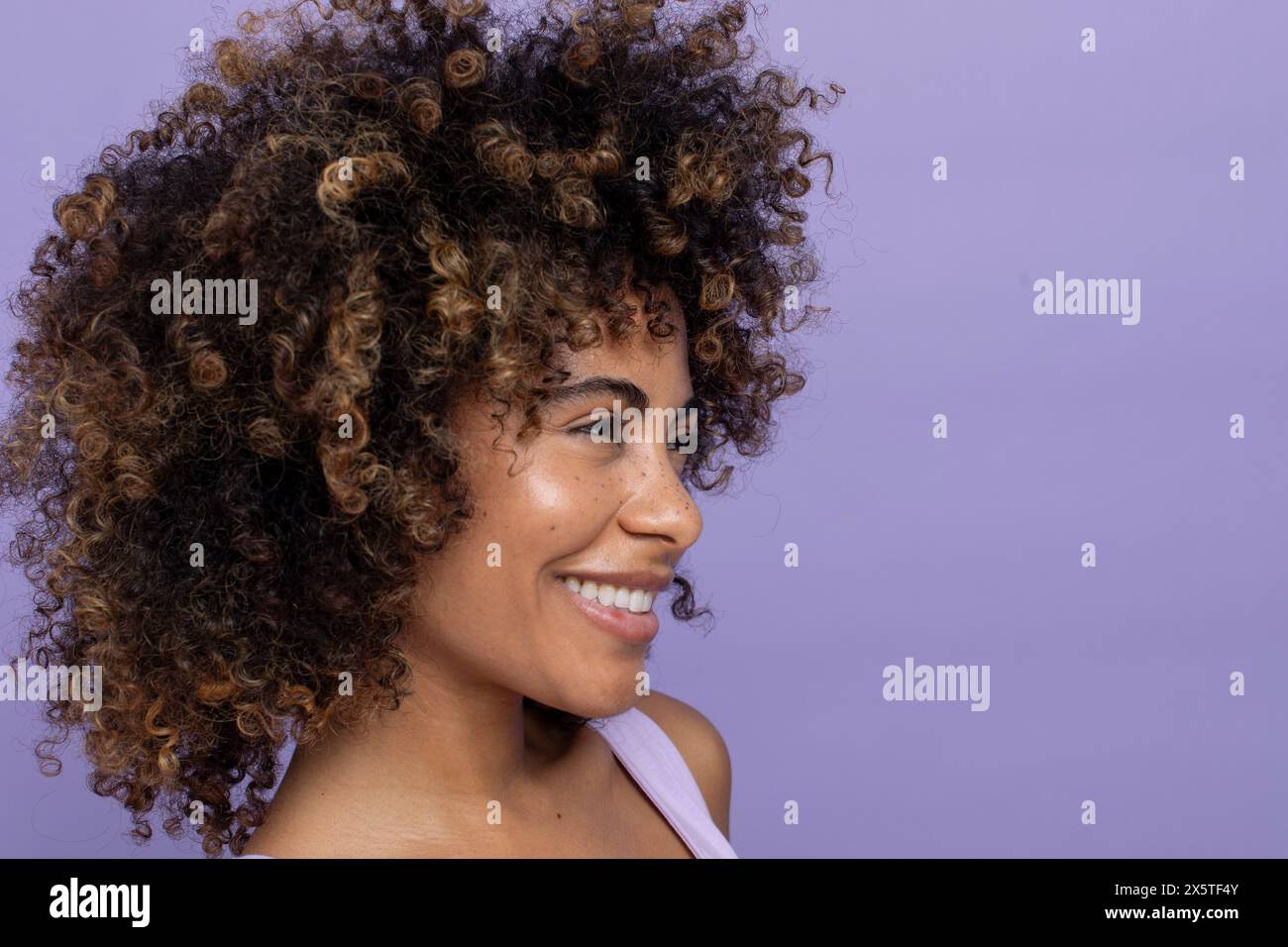 Brune souriante aux cheveux bouclés Banque D'Images