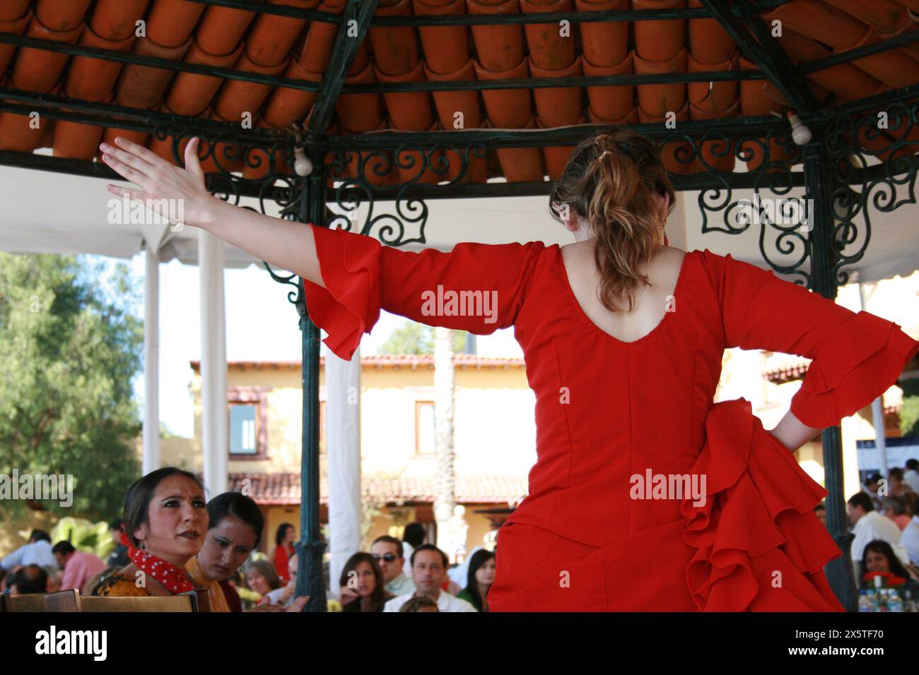 Danseuse de flamenco dans une robe rouge avec danse publique dans un kiosque. Banque D'Images