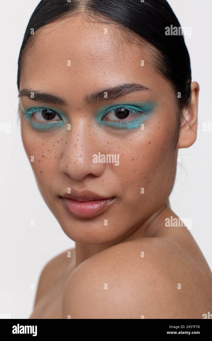 Portrait de femme avec les cheveux noirs et le maquillage bleu Banque D'Images