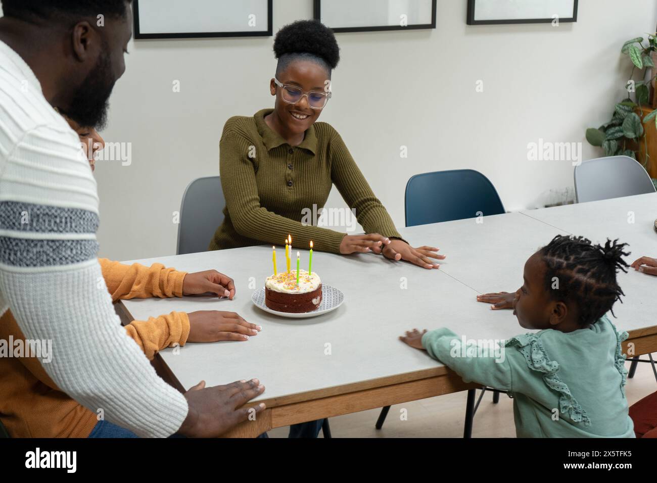 Famille avec enfants (2-3, 12-13) célébrant l'anniversaire à la maison Banque D'Images