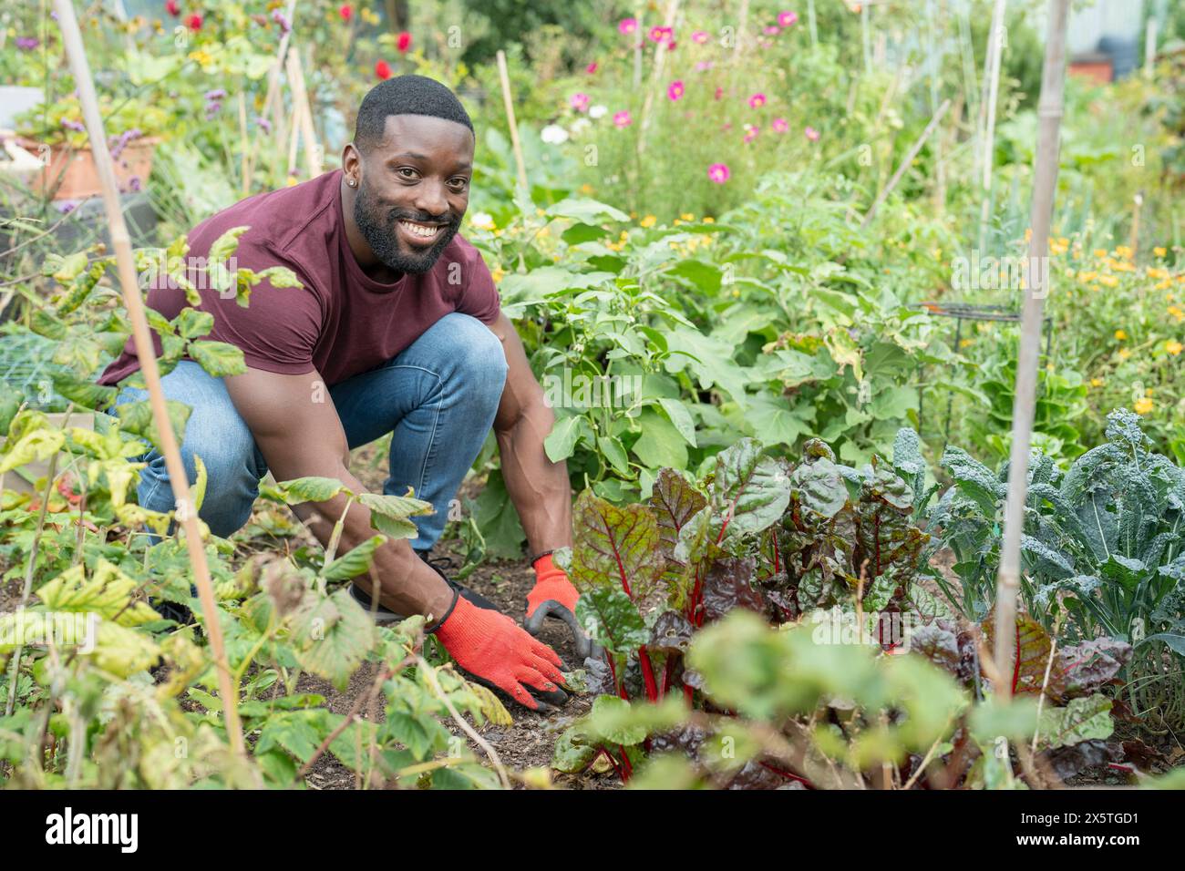 Portrait d'homme souriant travaillant dans un jardin urbain Banque D'Images