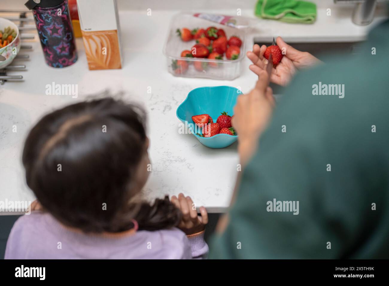 Père et fille coupant des fraises Banque D'Images