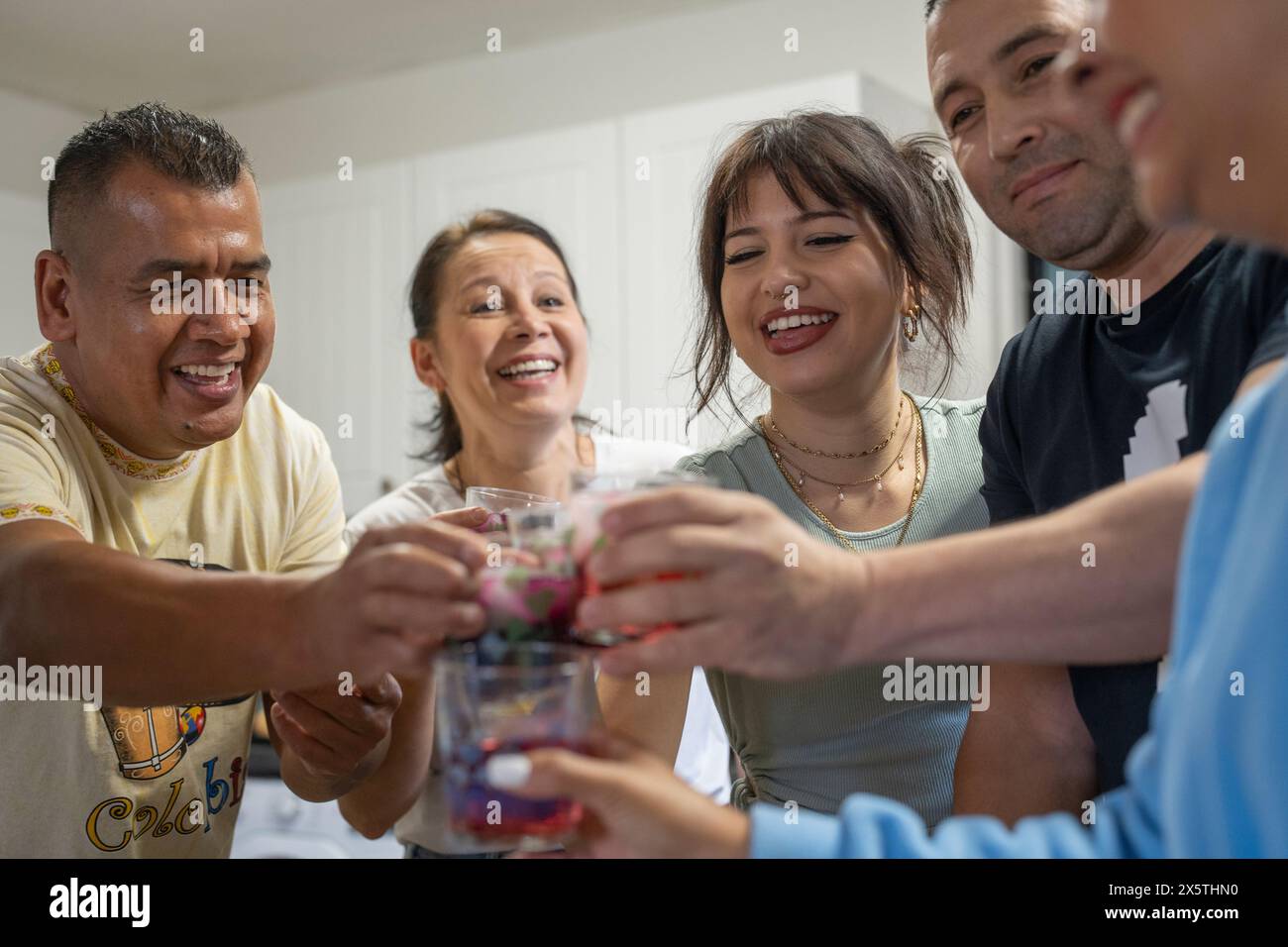 Membres de la famille élevant des toasts de fête dans la cuisine Banque D'Images