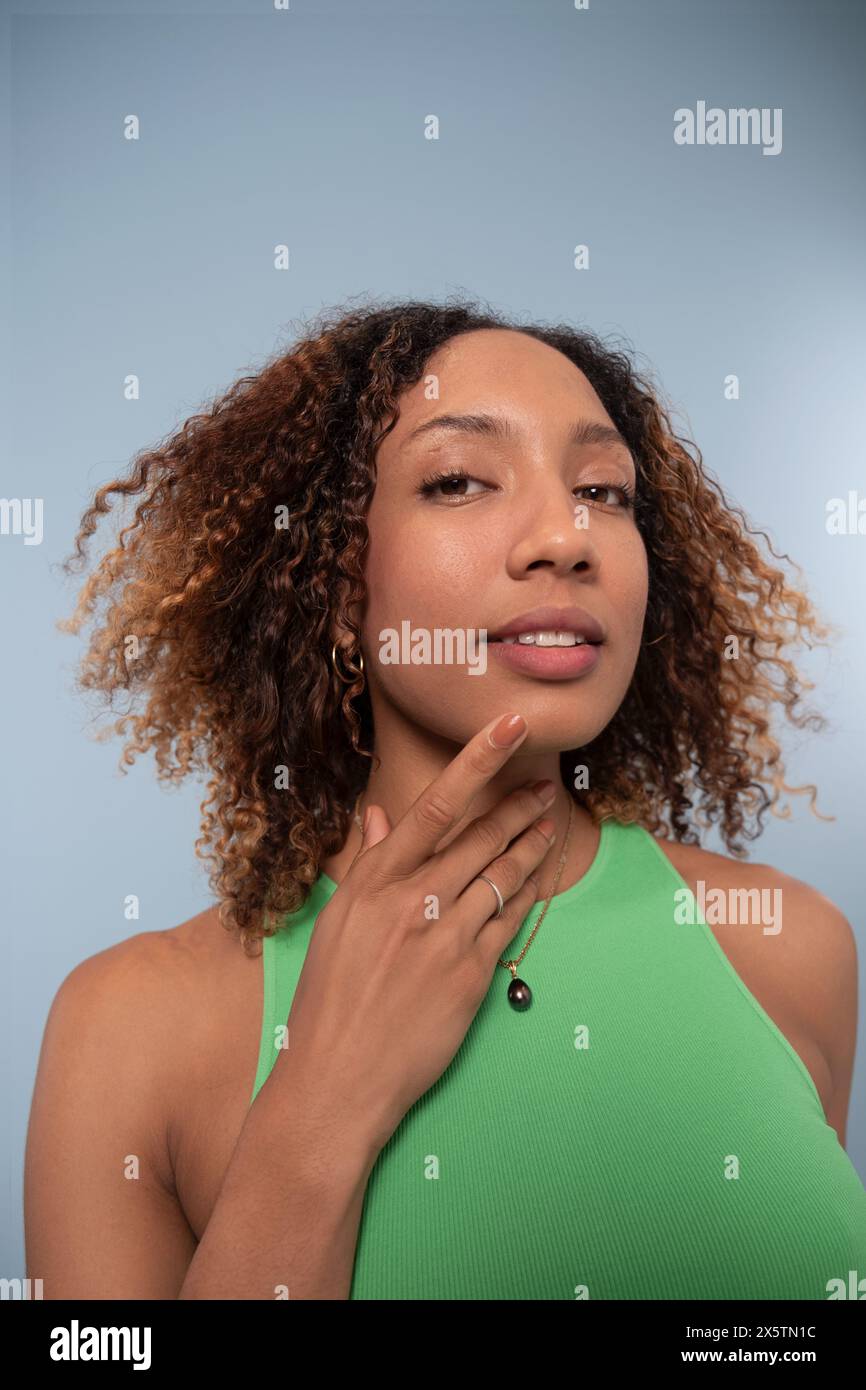Portrait de femme avec cheveux bouclés et top vert Banque D'Images