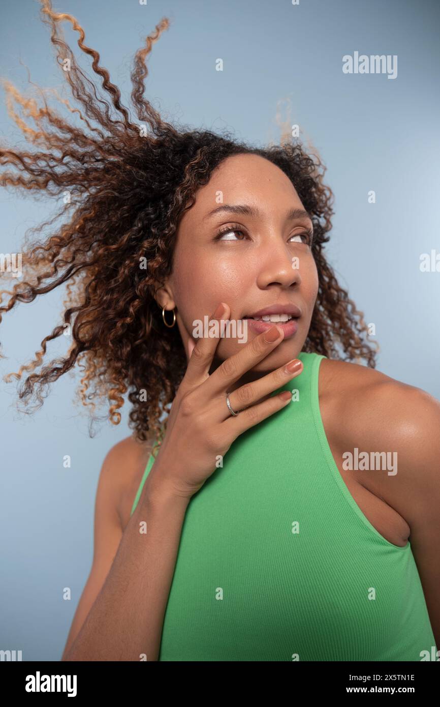 Portrait de femme avec cheveux bouclés et top vert Banque D'Images