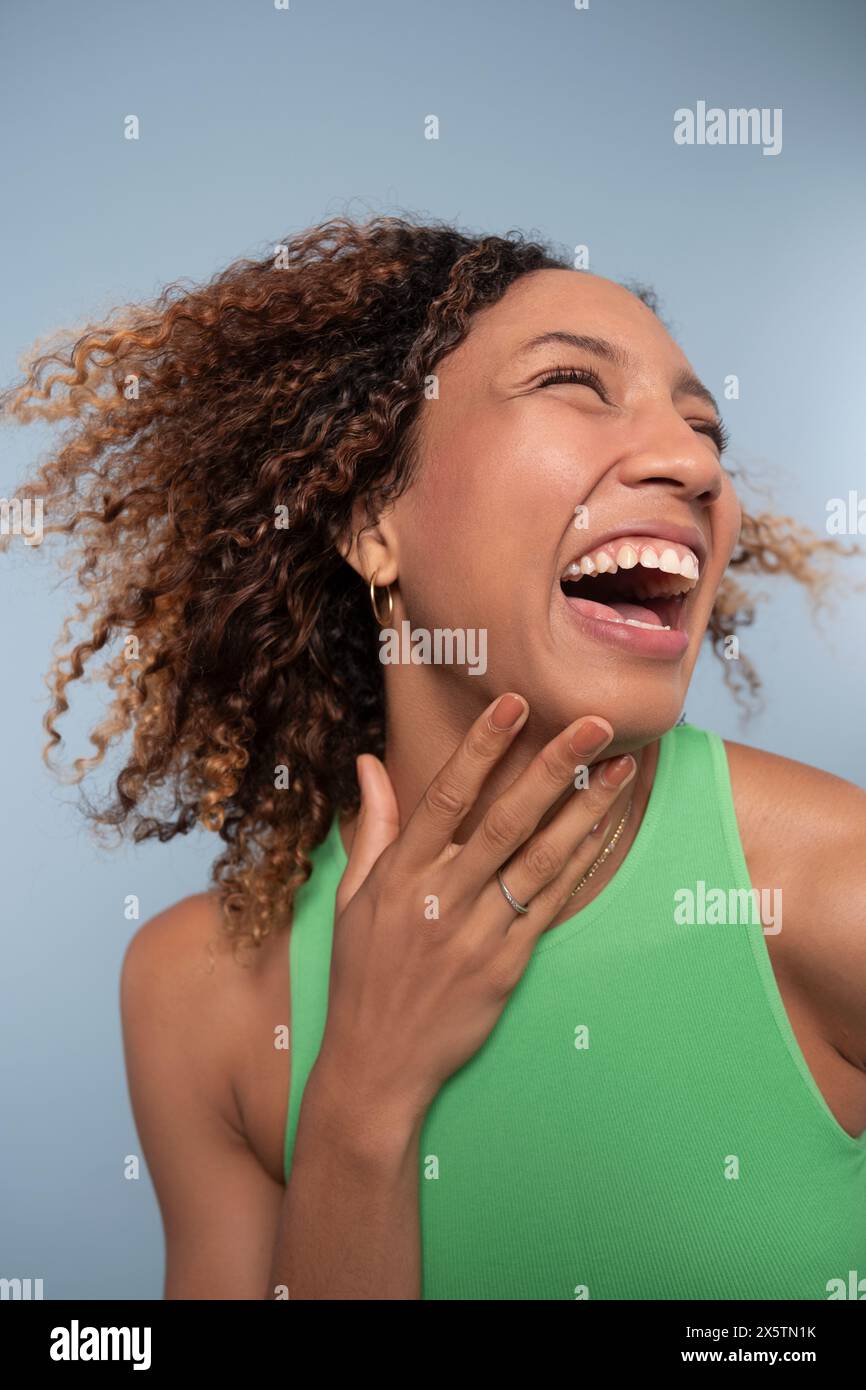 Portrait de femme aux cheveux bouclés, riant Banque D'Images