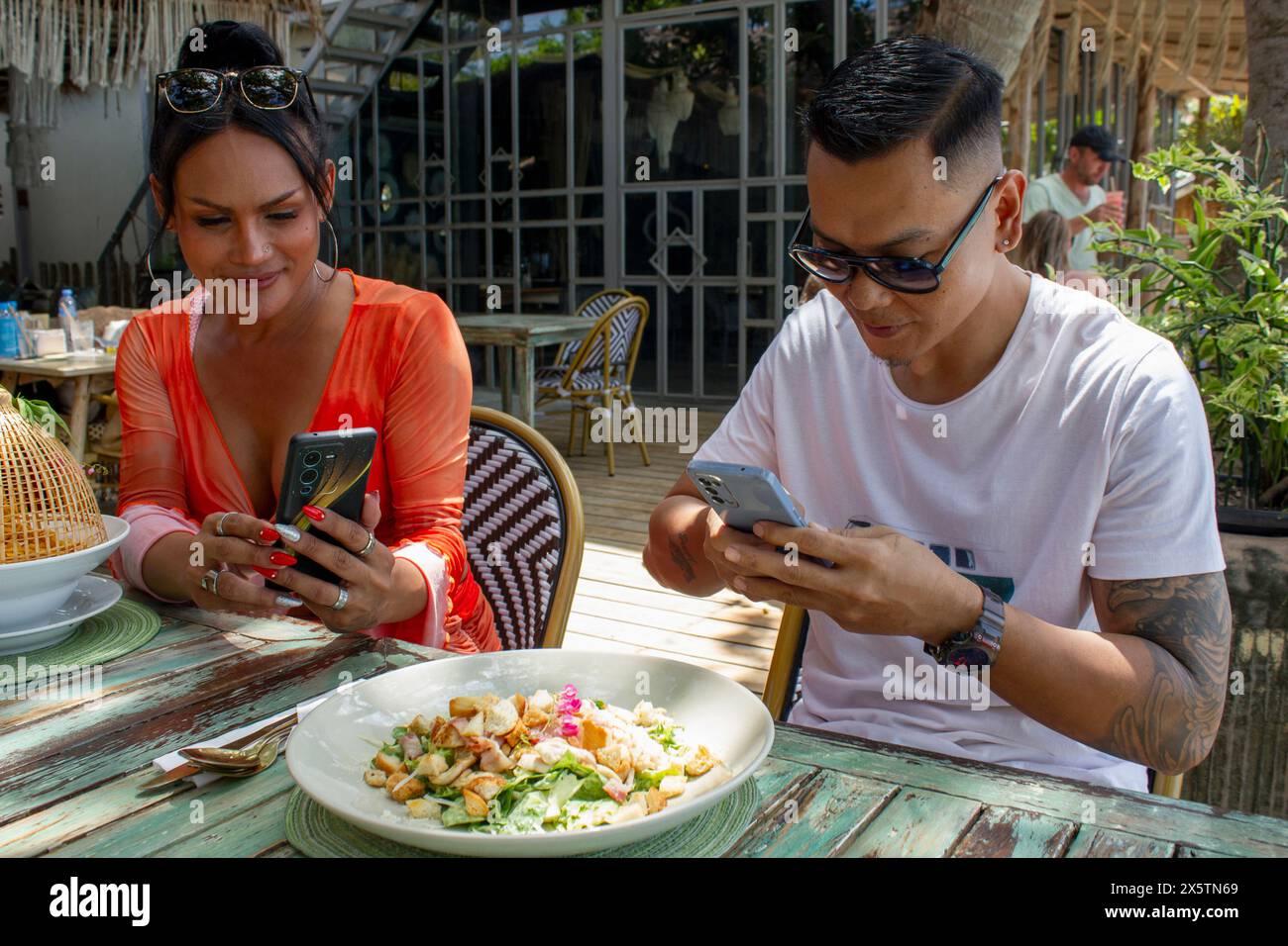 Amis gourmands photographiant la nourriture dans un restaurant Banque D'Images