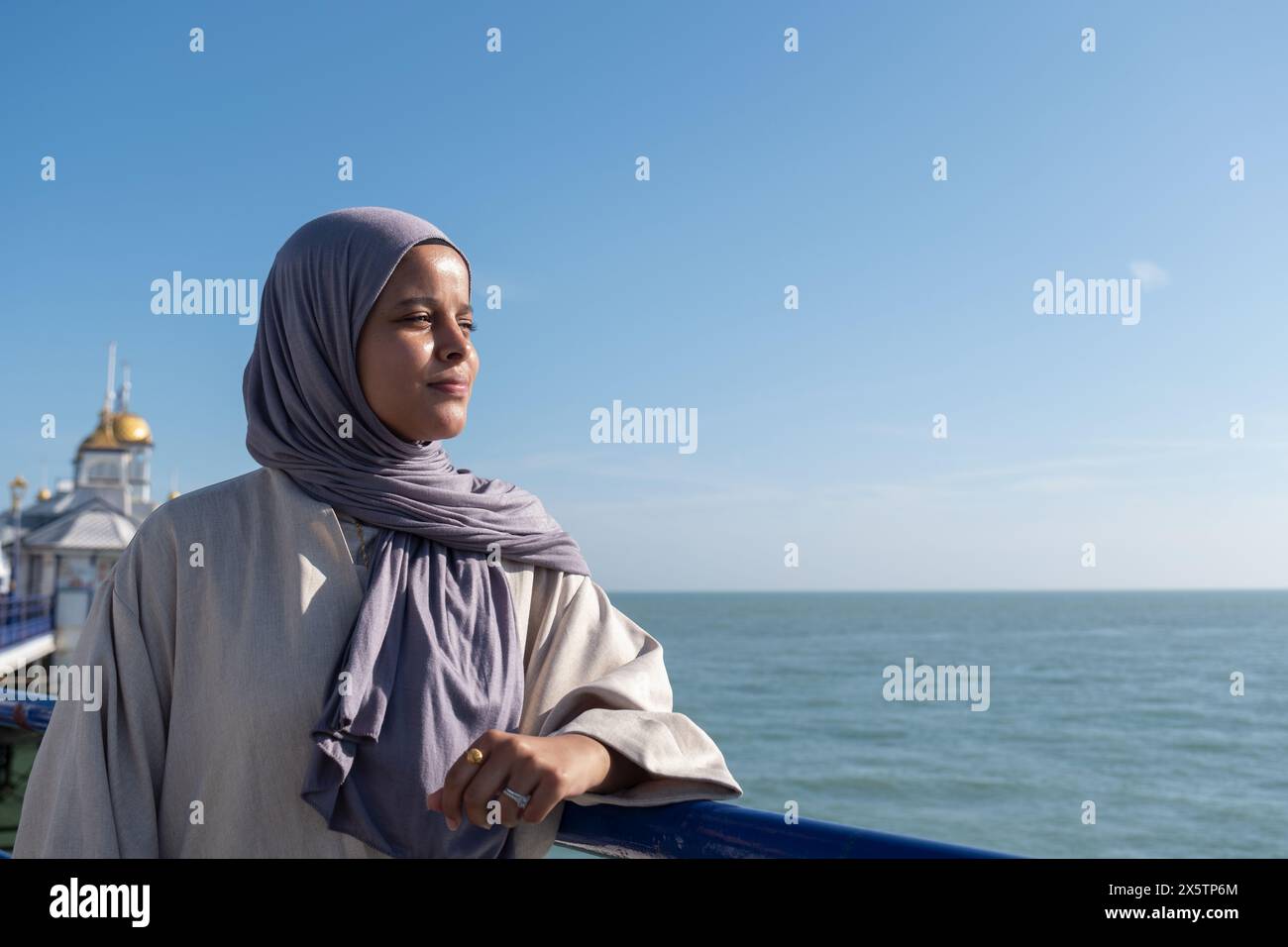 Portrait de femme musulmane réfléchie regardant la mer un jour ensoleillé Banque D'Images