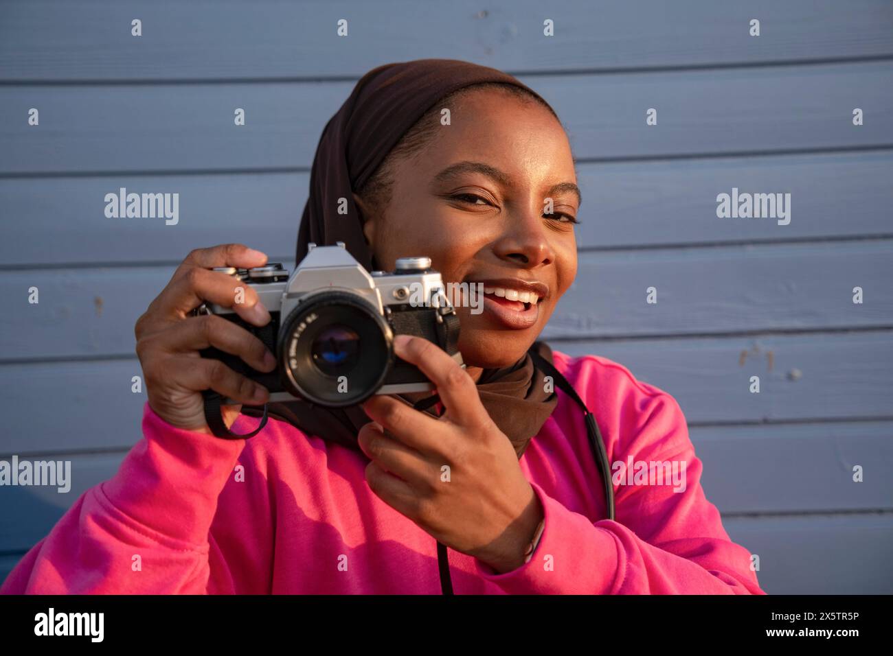 Portrait de femme musulmane souriante photographiant avec un appareil photo analogique Banque D'Images