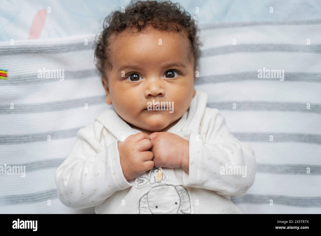 Portrait de bébé fille avec les cheveux bouclés et les yeux bruns Banque D'Images