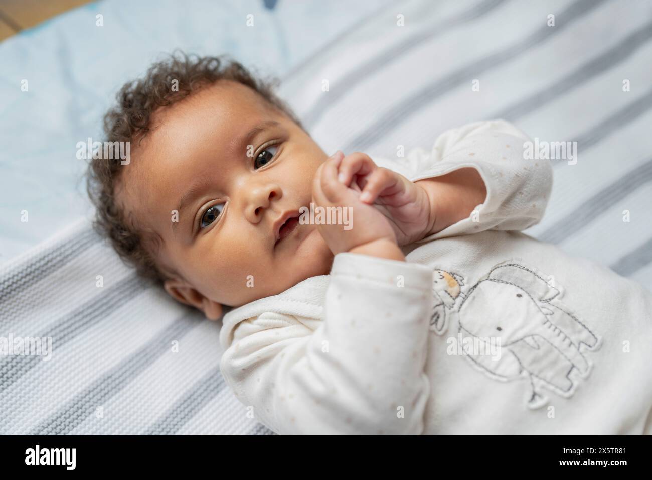 Portrait de bébé fille avec les cheveux bouclés et les yeux bruns Banque D'Images