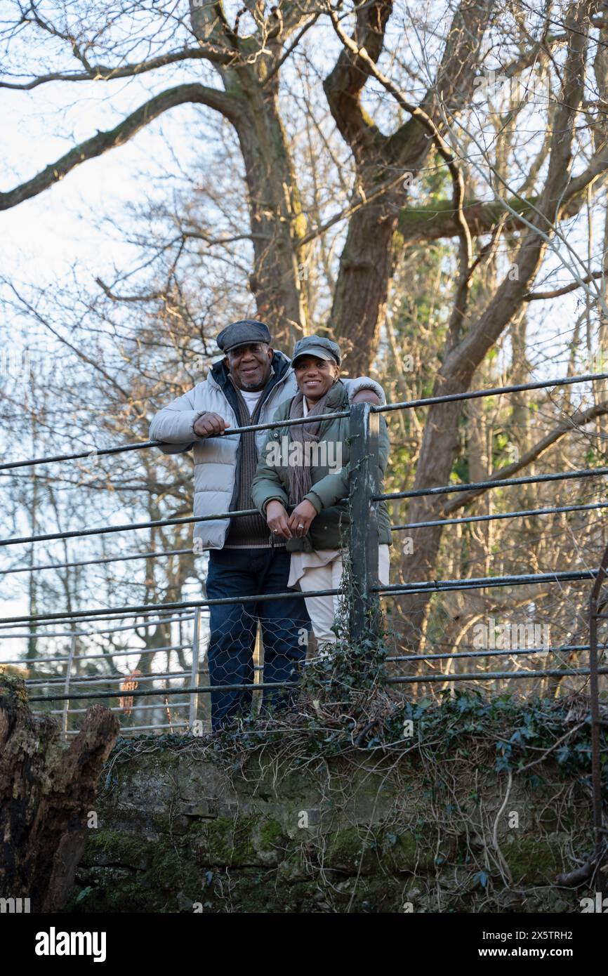 Couple senior debout près de la clôture, regardant la caméra Banque D'Images
