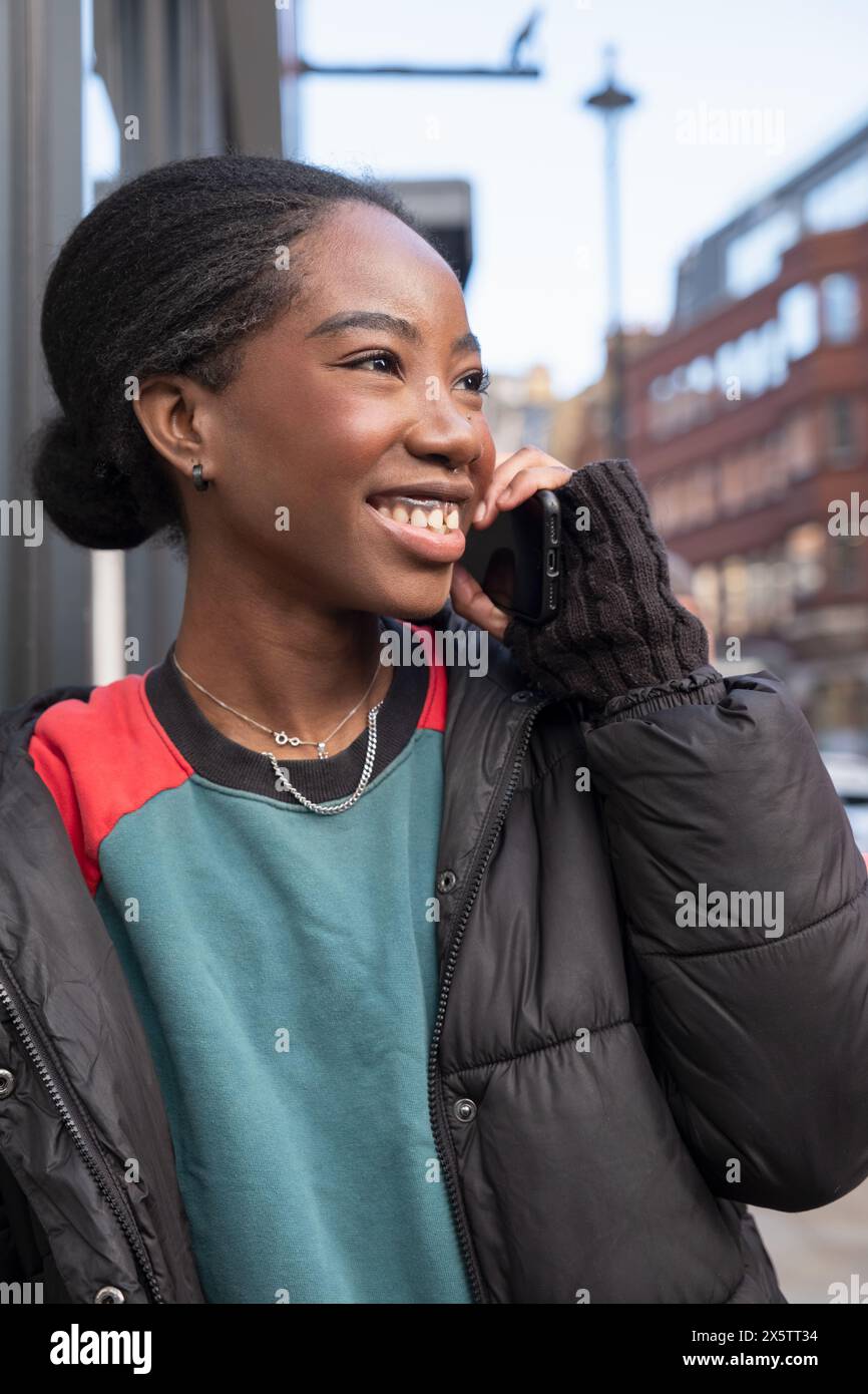 Portrait de jeune femme heureuse parlant téléphone Banque D'Images