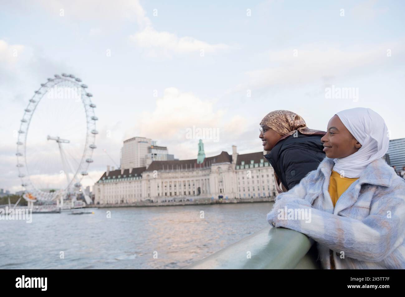 Royaume-Uni, Londres, touristes femmes dans les hijabs regardant le London Eye sur la Tamise Banque D'Images