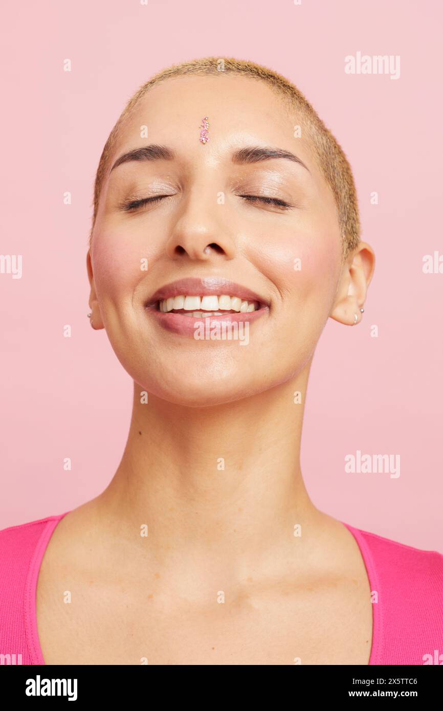 Portrait d'une femme souriante aux cheveux blonds courts, les yeux fermés Banque D'Images