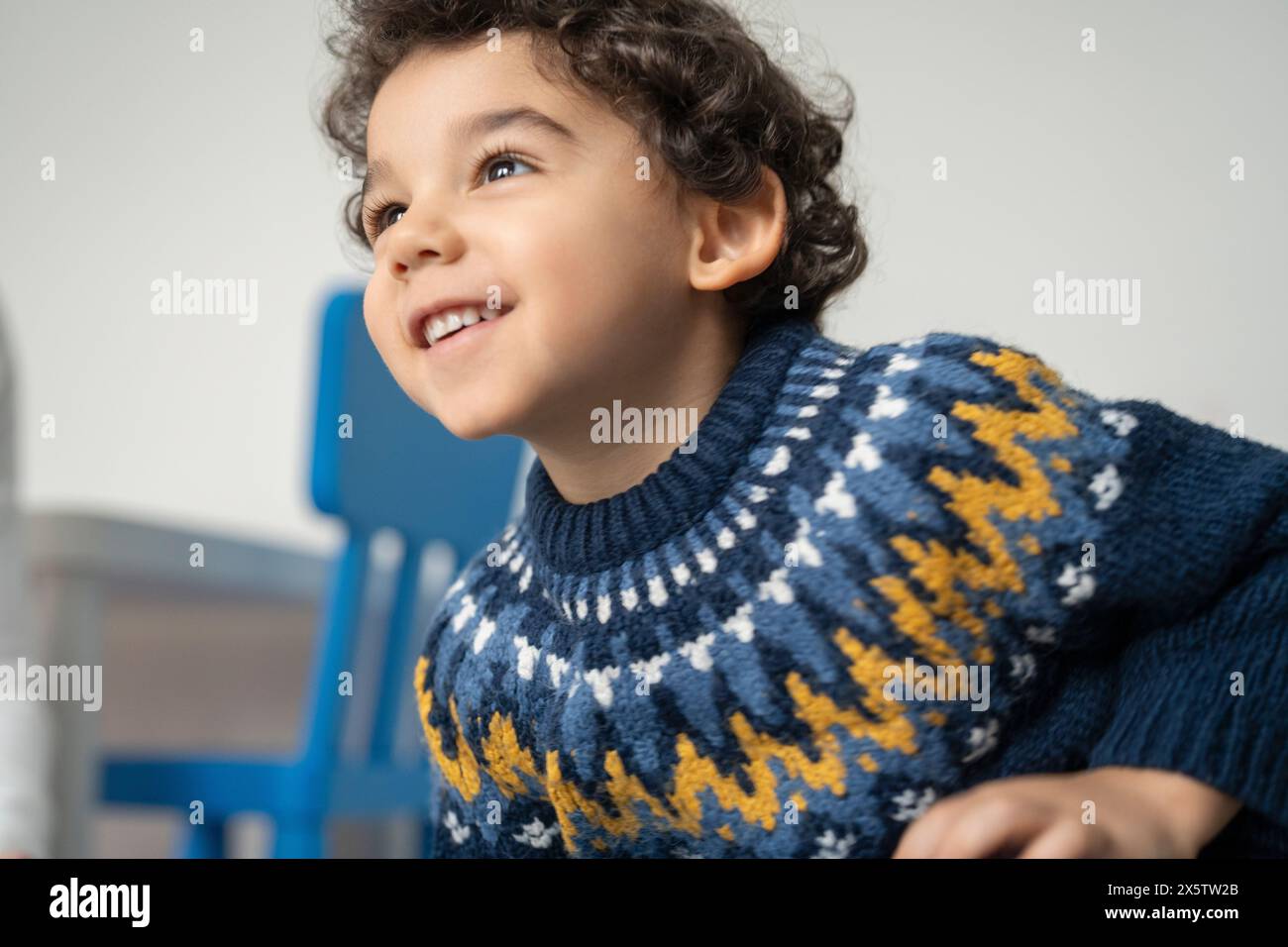 Garçon souriant (2-3) avec les cheveux bouclés Banque D'Images