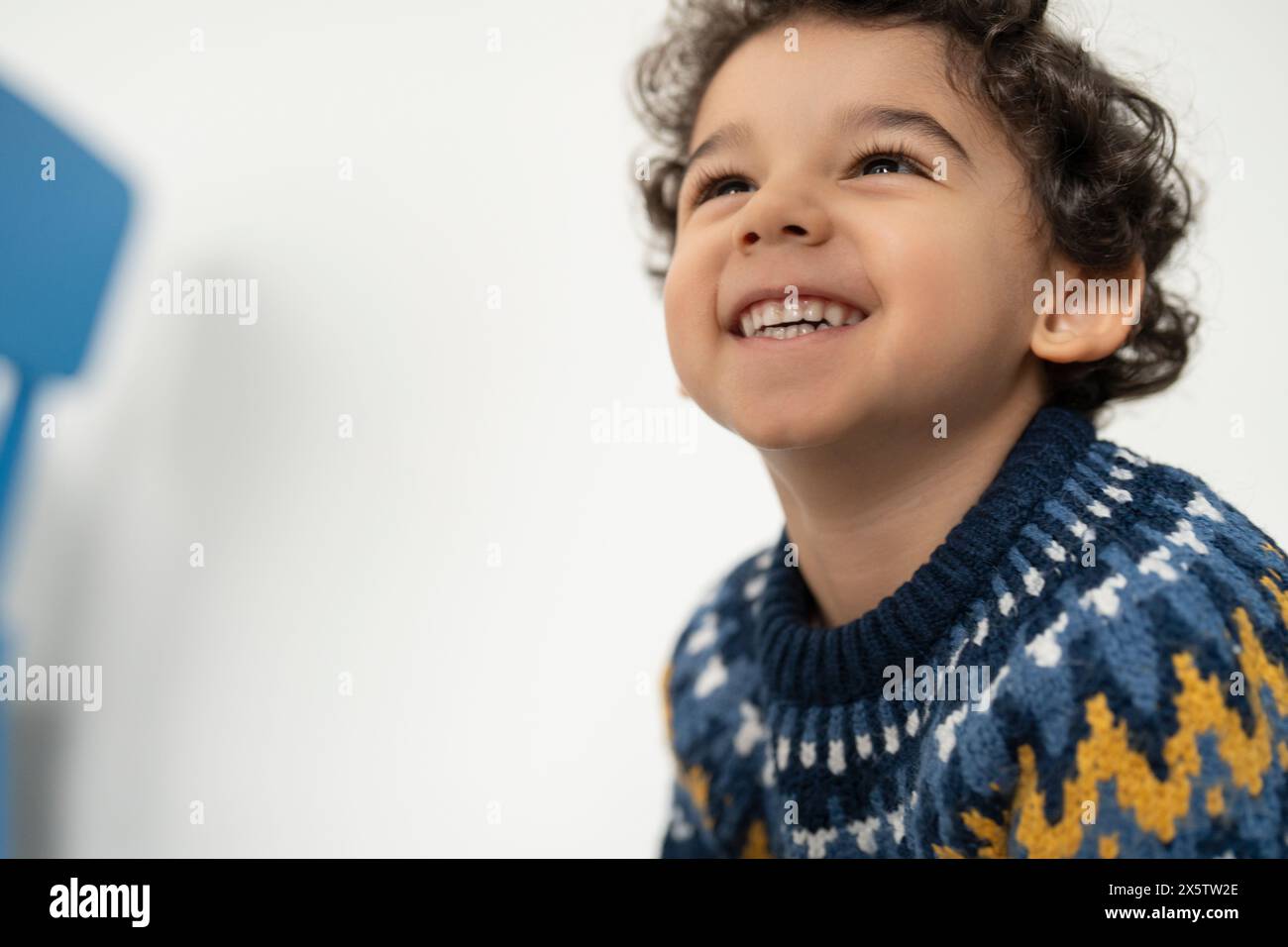 Garçon souriant (2-3) avec les cheveux bouclés Banque D'Images