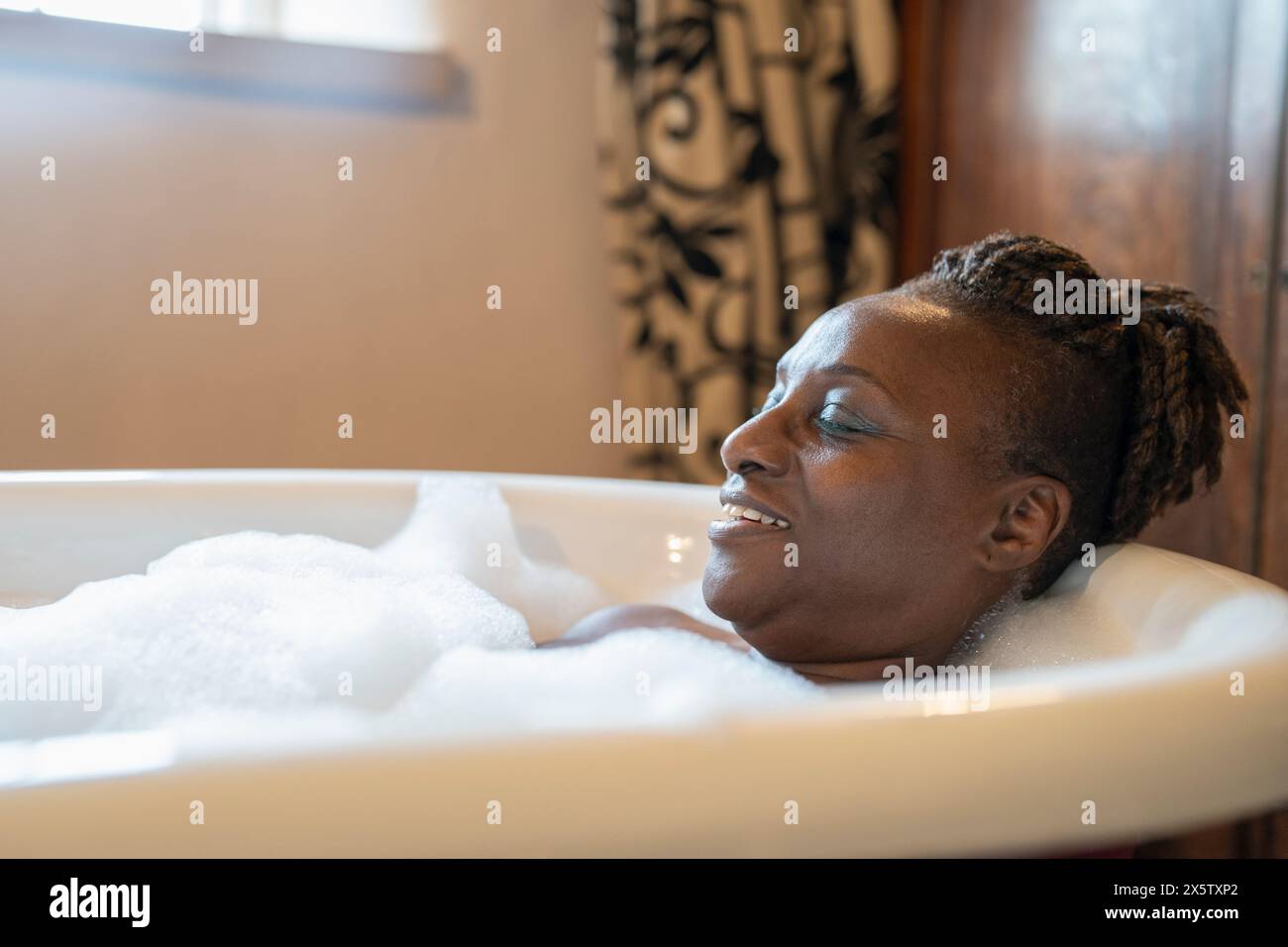 Femme senior prenant un bain moussant Banque D'Images