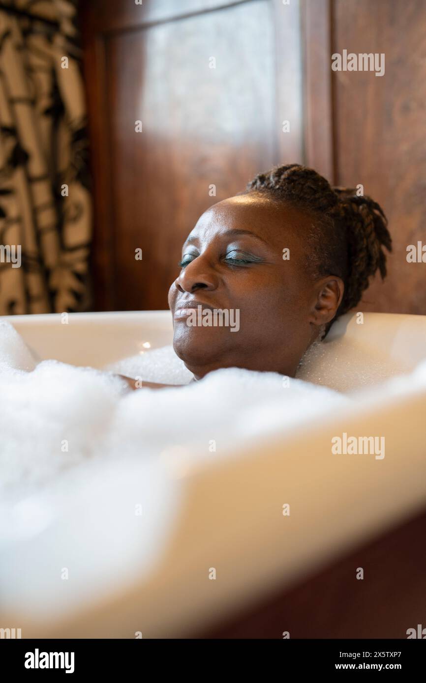 Femme senior prenant un bain moussant Banque D'Images
