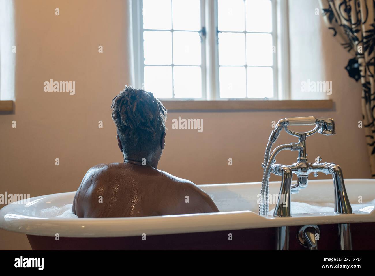 Femme senior prenant un bain moussant Banque D'Images